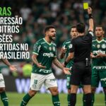 Jogadores do Palmeiras se manifestam ao árbitro durante uma partida, enquanto o árbitro exibe um cartão amarelo.