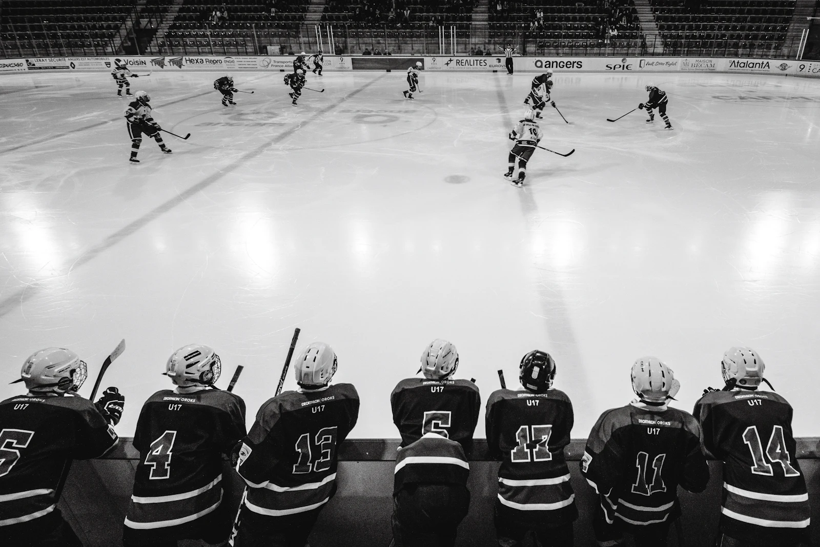 View over a hockey team bench toward a game in progress in an indoor arena