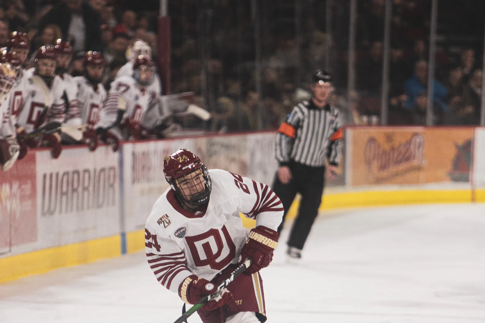 Hockey forward in a white jersey skating with the puck, illustrating our Ian Amsbaugh profile