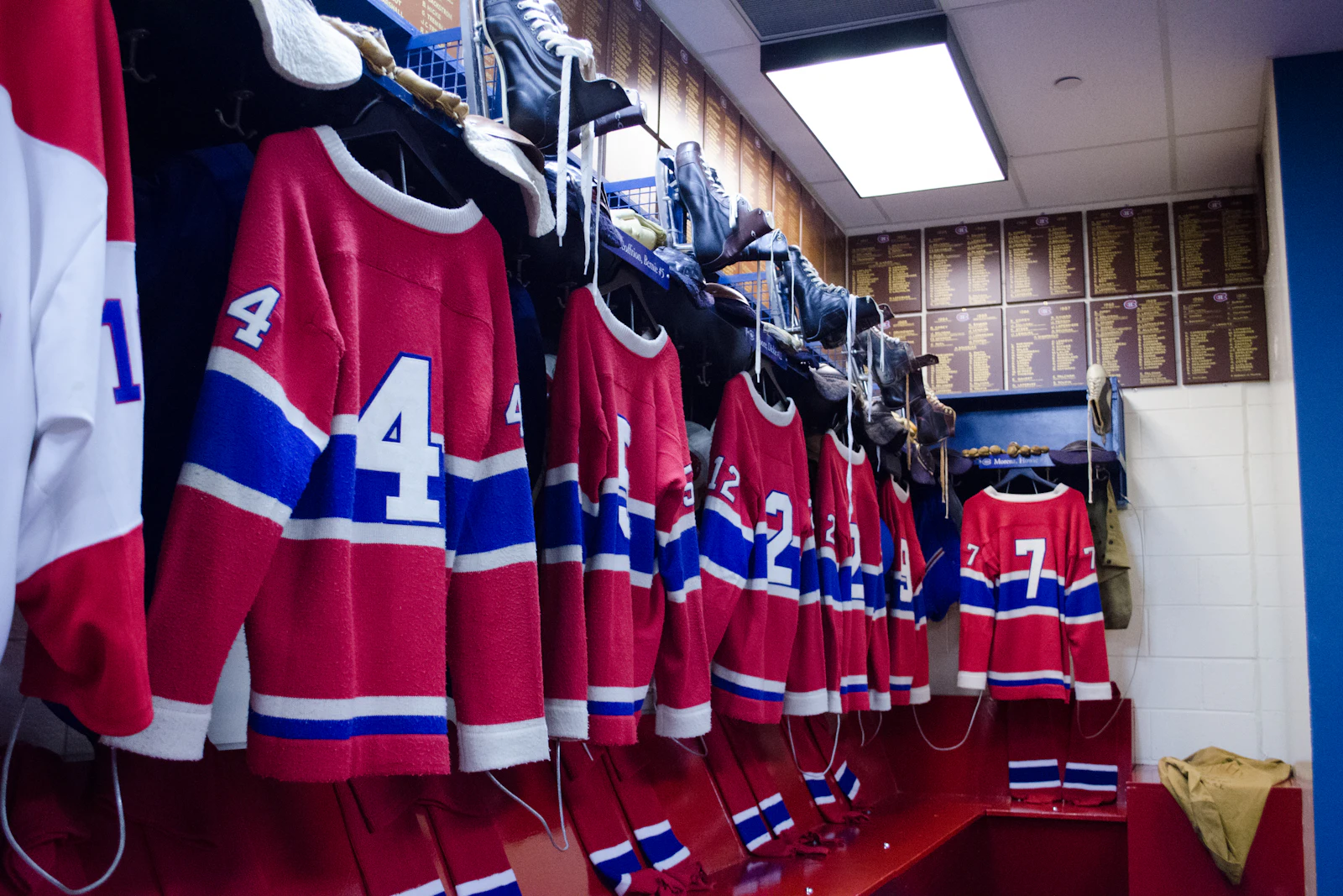 Hockey jerseys hanging in a locker room, illustrating the history of Tulsa Oilers logos
