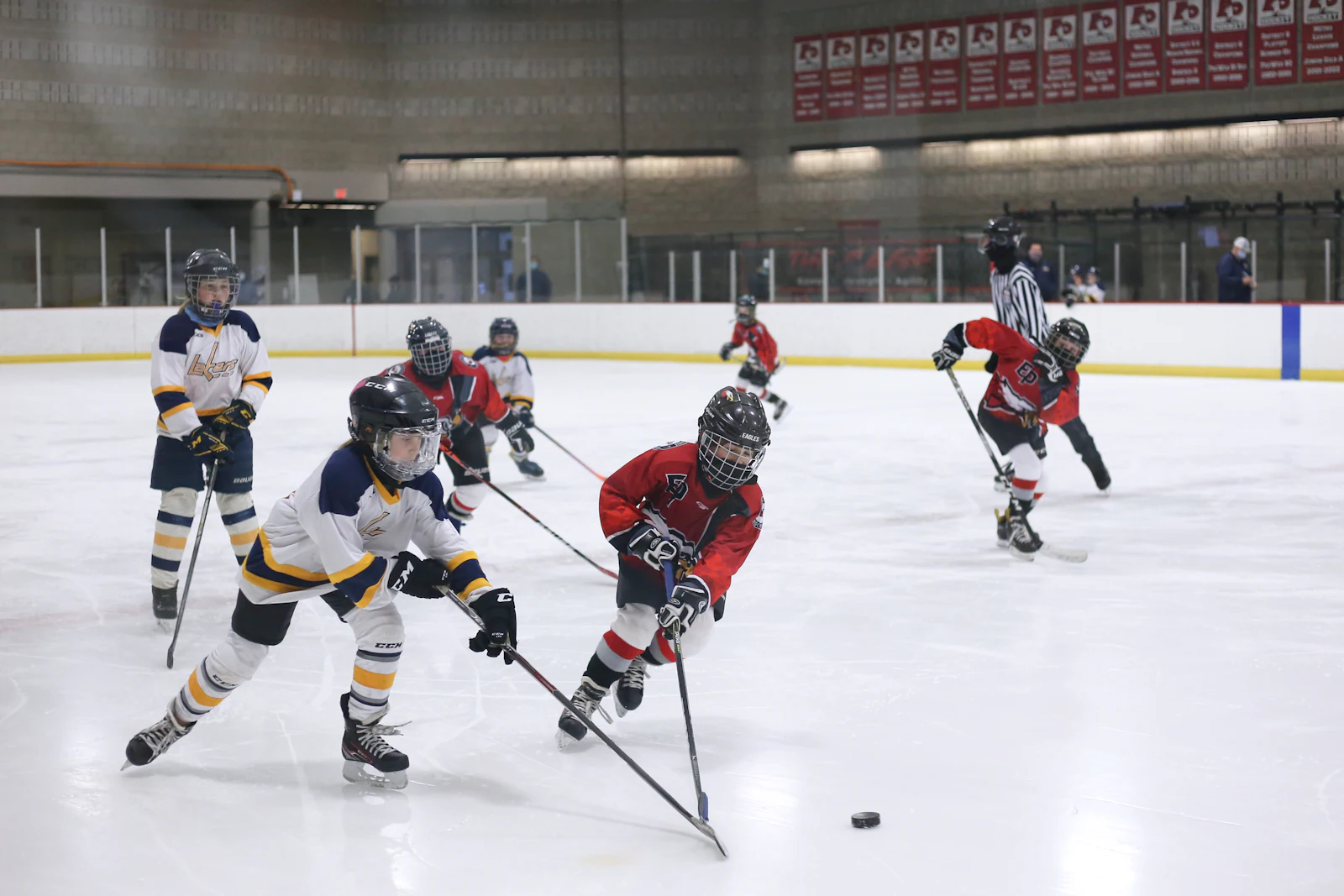 Hockey players racing up the ice for the puck, illustrating early Tulsa Oilers results in 2026-27
