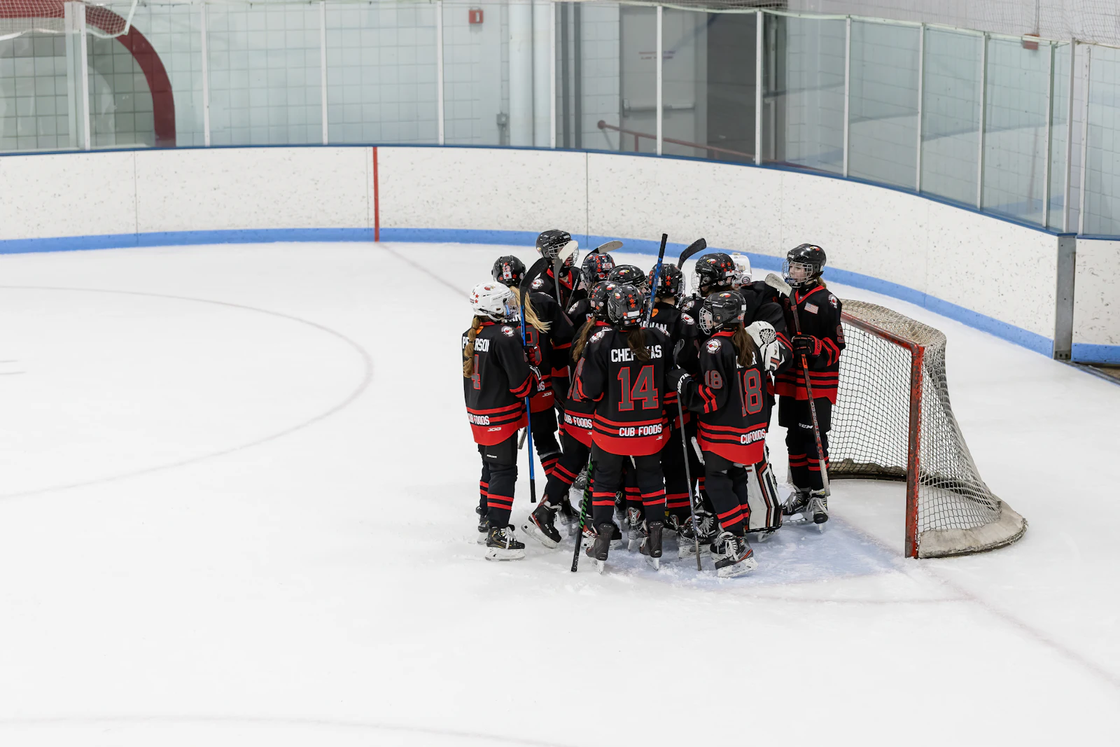 Hockey team huddle on the ice, illustrating the Anaheim Ducks affiliation with the Tulsa Oilers