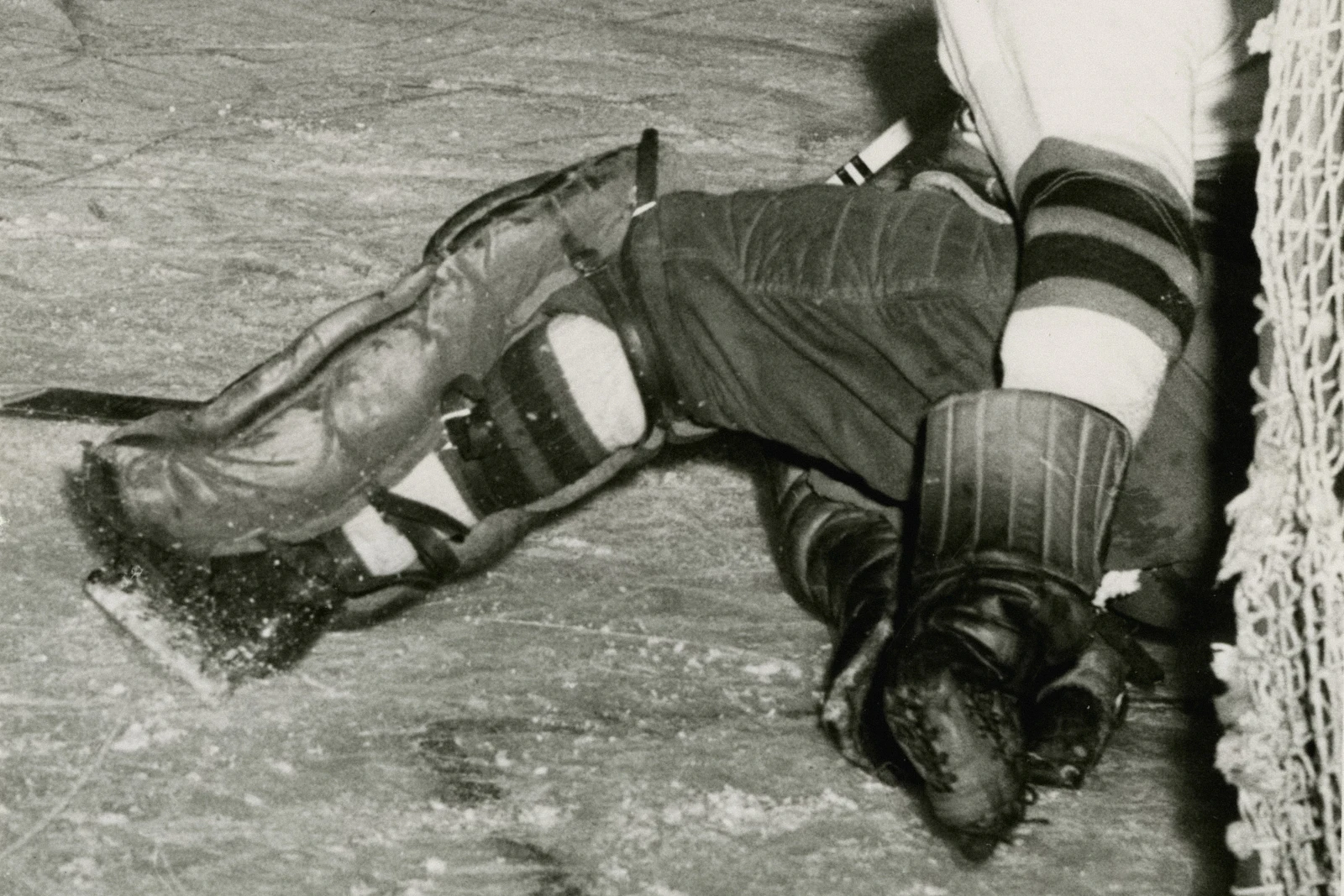 Archival black-and-white hockey action near the net, evoking the Oklahoma City Blazers rivalry era